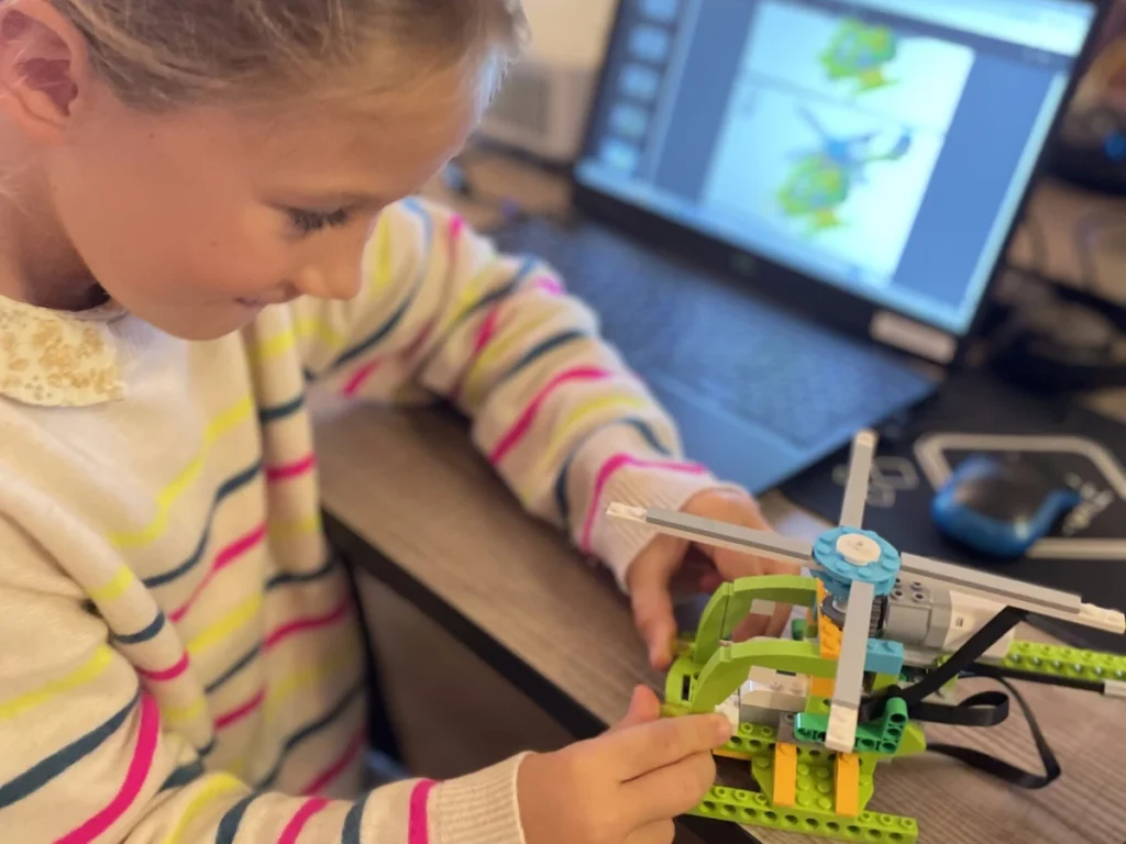 Petite fille fabrique son robot Lego hélicoptère